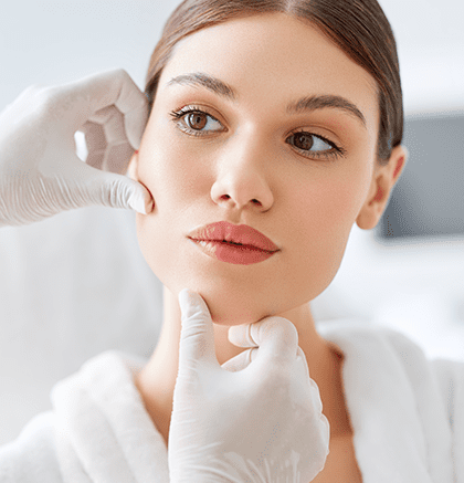 Dermatologist examining teenage girl with acne during skin consultation