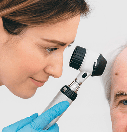 Dermatologist examining patient’s mole for possible melanoma