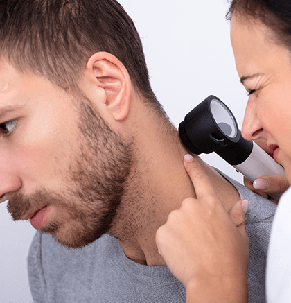 Dermatologist examining patient’s skin for squamous cell carcinoma